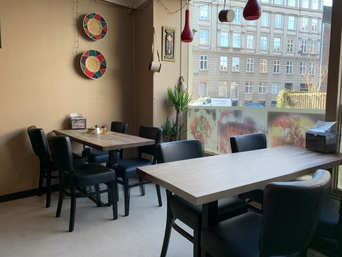 The dining room at Hidmona with wooden tables and woven baskets by the window